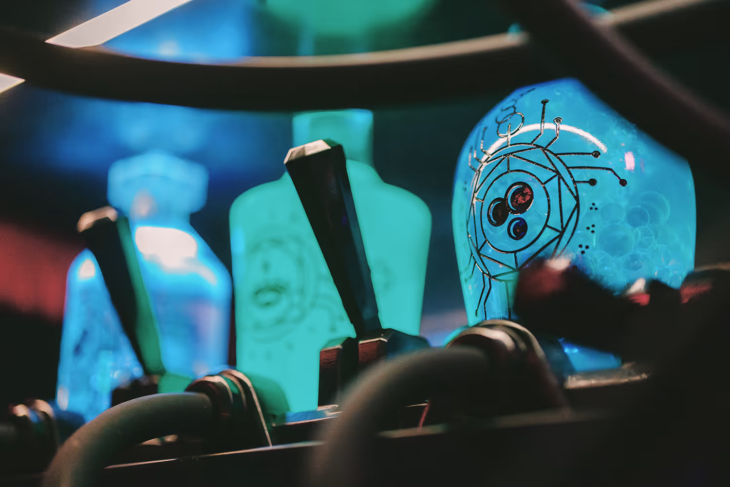 Close-up of blue translucent bottles with circuit-like designs and connected black tubes.